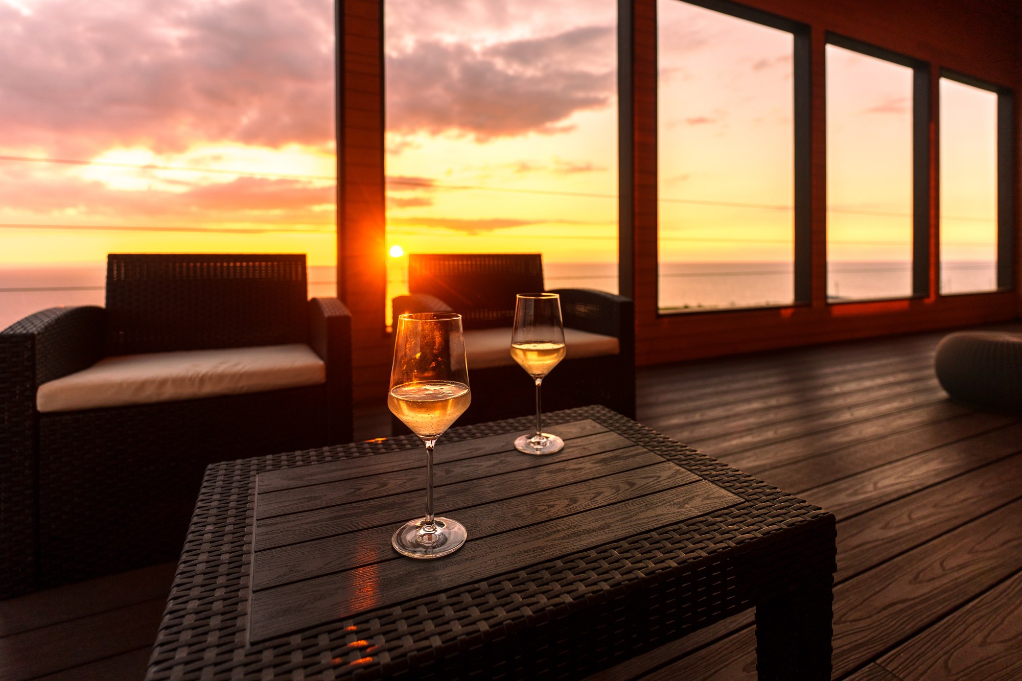 The deck and dining table at dusk, overlooking the sea